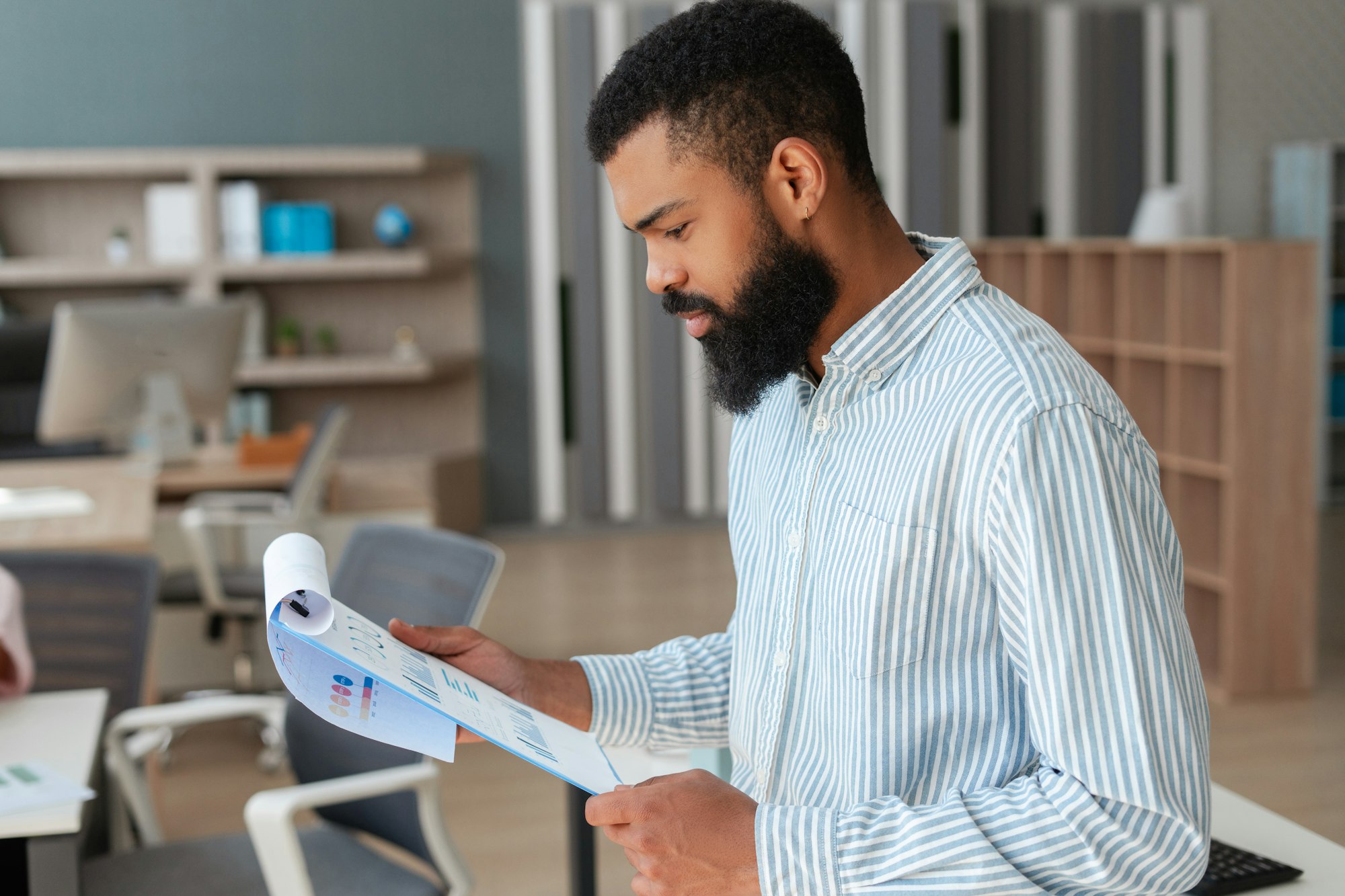 Focused businessman analyzing charts and graphs in modern office
